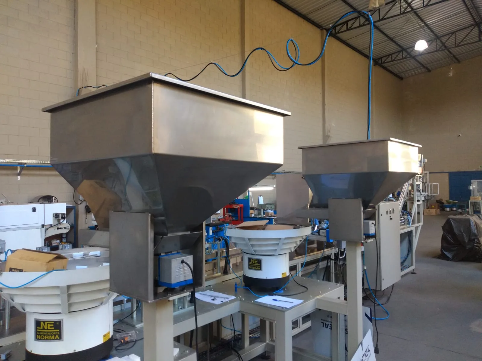Máquina industrial com proteções amarelas e painel de comando