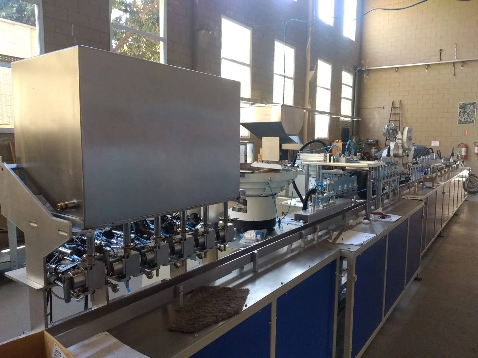 Máquina industrial com estrutura de proteção e esteira